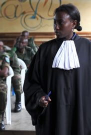 Lawyer Amani Kahatwa standing in a courtroom with military personnel in the background